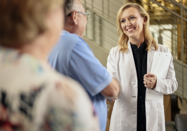 Smiling doctor shaking hands with a patient.